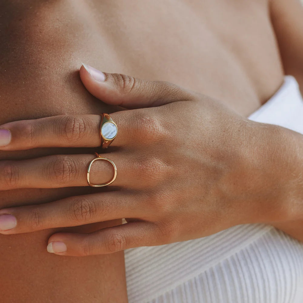 Anillo dorado minimalista con diseño oval abierto en acero inoxidable 316L y baño de oro 18K, resistente al agua.