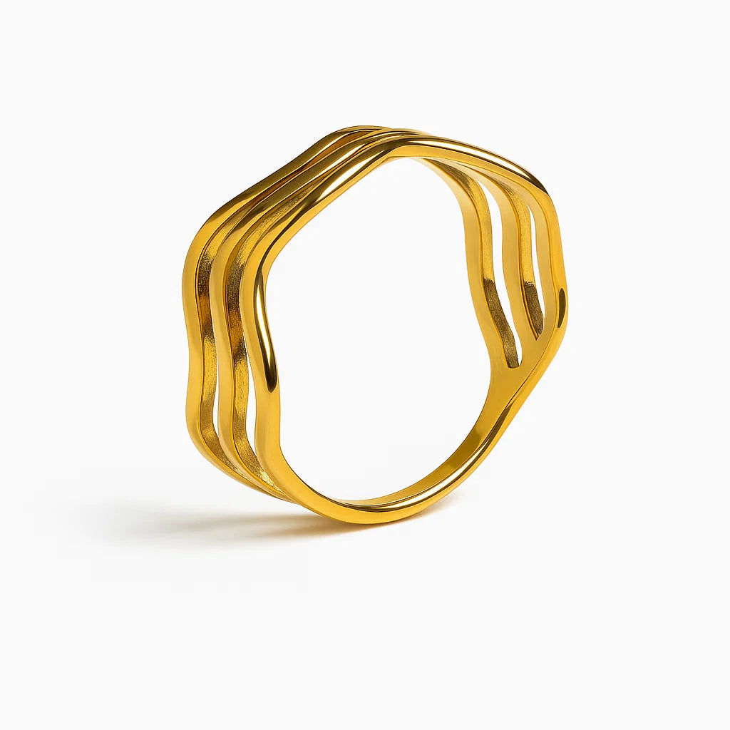 Anillo dorado “Ocean” con diseño de tres ondas, baño de oro 18K sobre acero inoxidable 316L, resistente al agua.