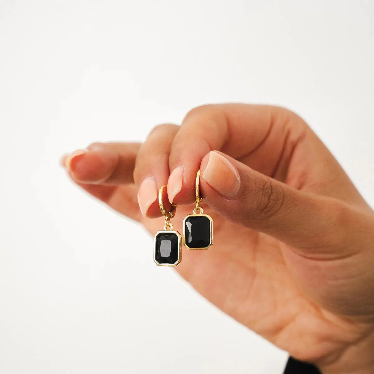 Aros dorados tipo argolla con colgantes rectangulares de cristal negro en baño de oro 18K de ZAYA