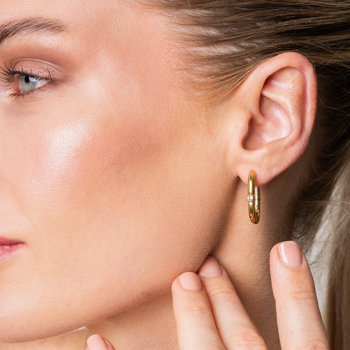 Aros ovalados dorados con pequeña circonia al frente, baño de oro 18K en acero inoxidable 316L.