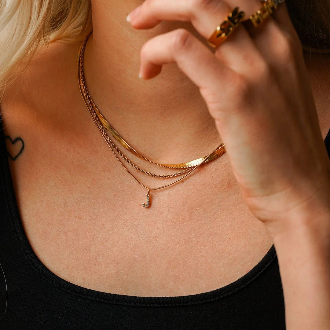 Collar ZAYA con letra inicial en pavé de zirconias, baño de oro 18K; hipoalergénico, a prueba de agua y con garantía de por vida.