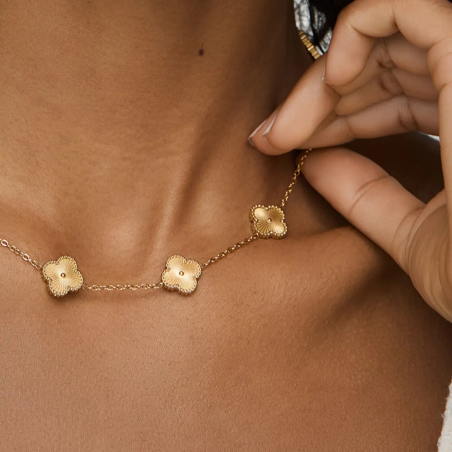 Collar ZAYA con tréboles dorados y borde texturizado, baño de oro 18K; hipoalergénico, a prueba de agua y con garantía de por vida.