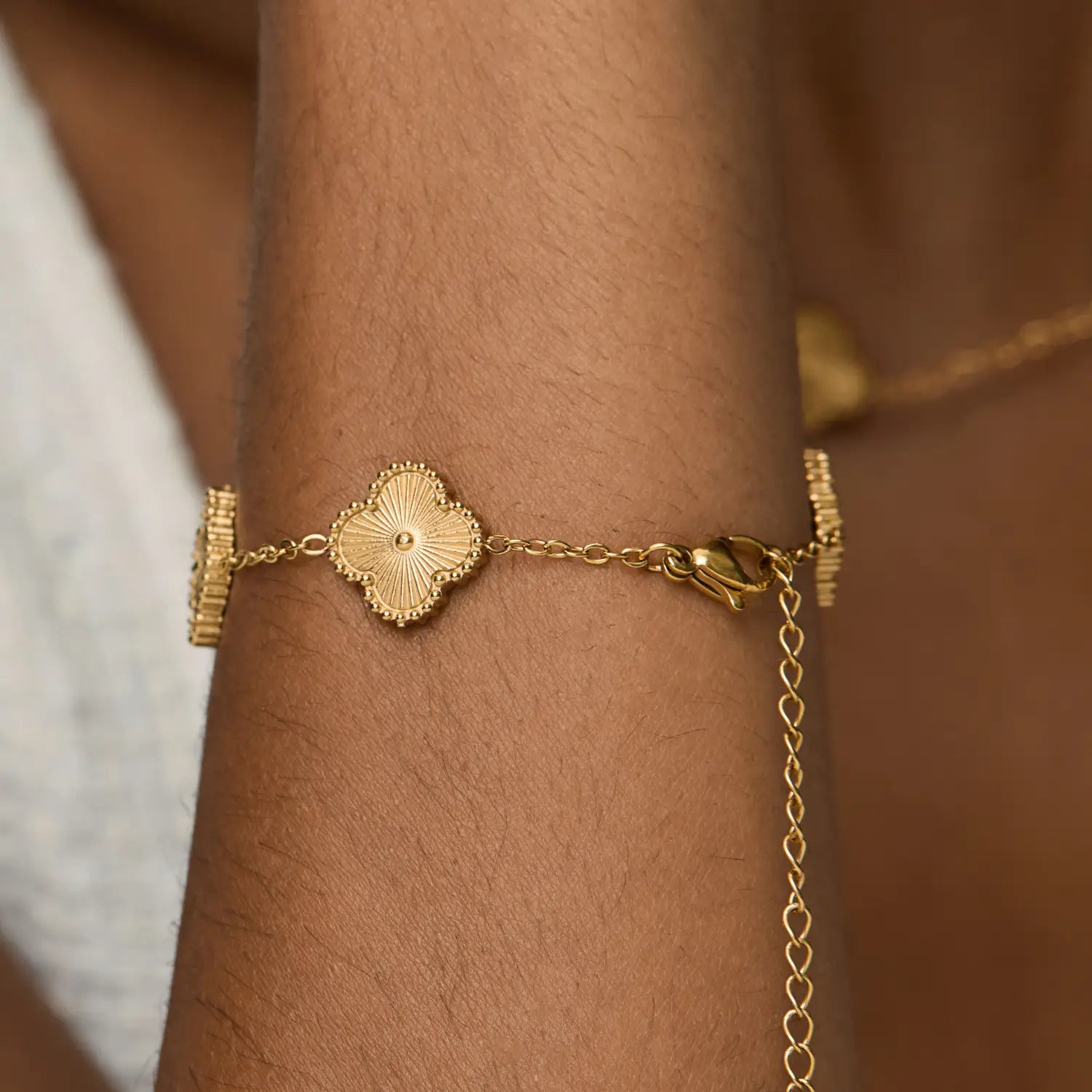Pulsera ZAYA con tréboles dorados y borde texturizado, baño de oro 18K; hipoalergénica, a prueba de agua y con garantía de por vida.