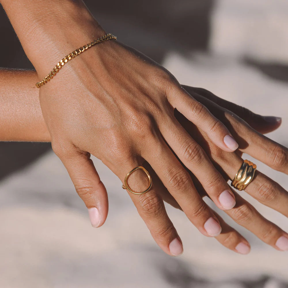 Anillo dorado minimalista con diseño oval abierto en acero inoxidable 316L y baño de oro 18K, resistente al agua.