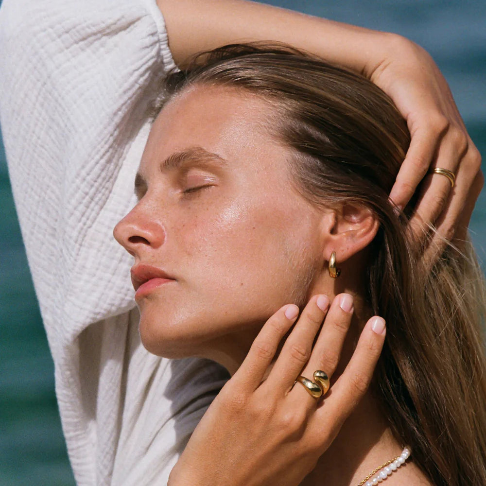 Anillo dorado abierto con dos extremos voluminosos tipo “twist” en acero inoxidable 316L y baño de oro 18K, resistente al agua.