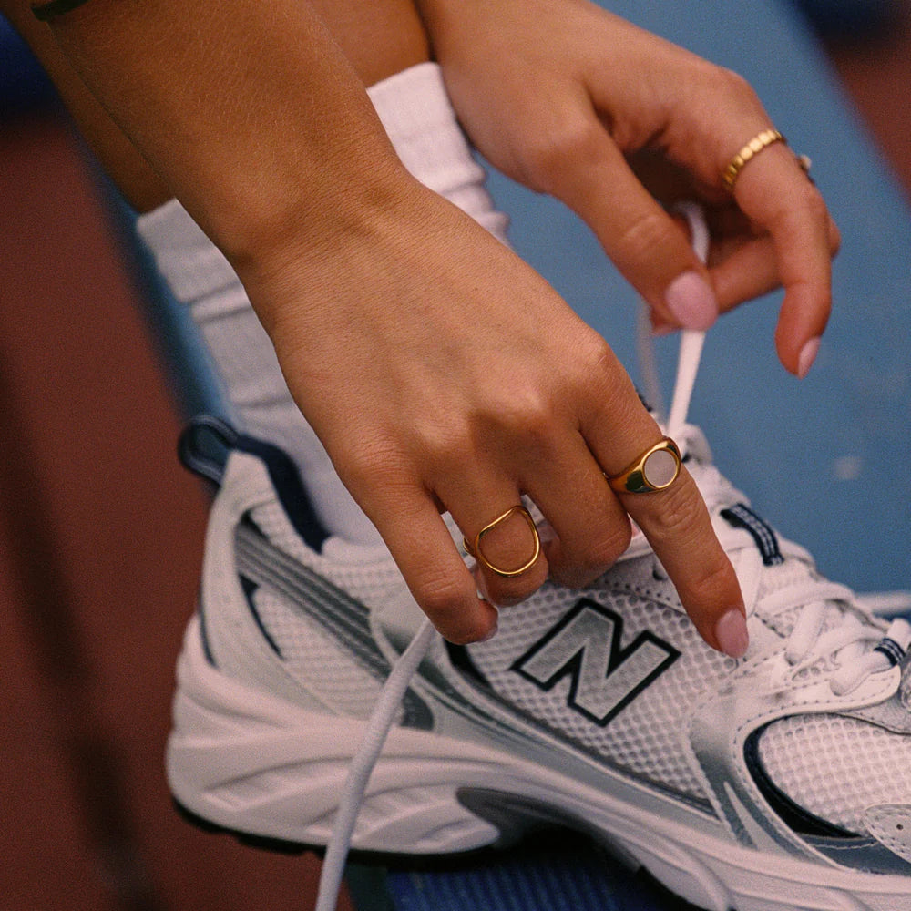 Anillo dorado tipo sello con centro de nácar (mother of pearl) en acero inoxidable 316L y baño de oro 18K, resistente al agua.