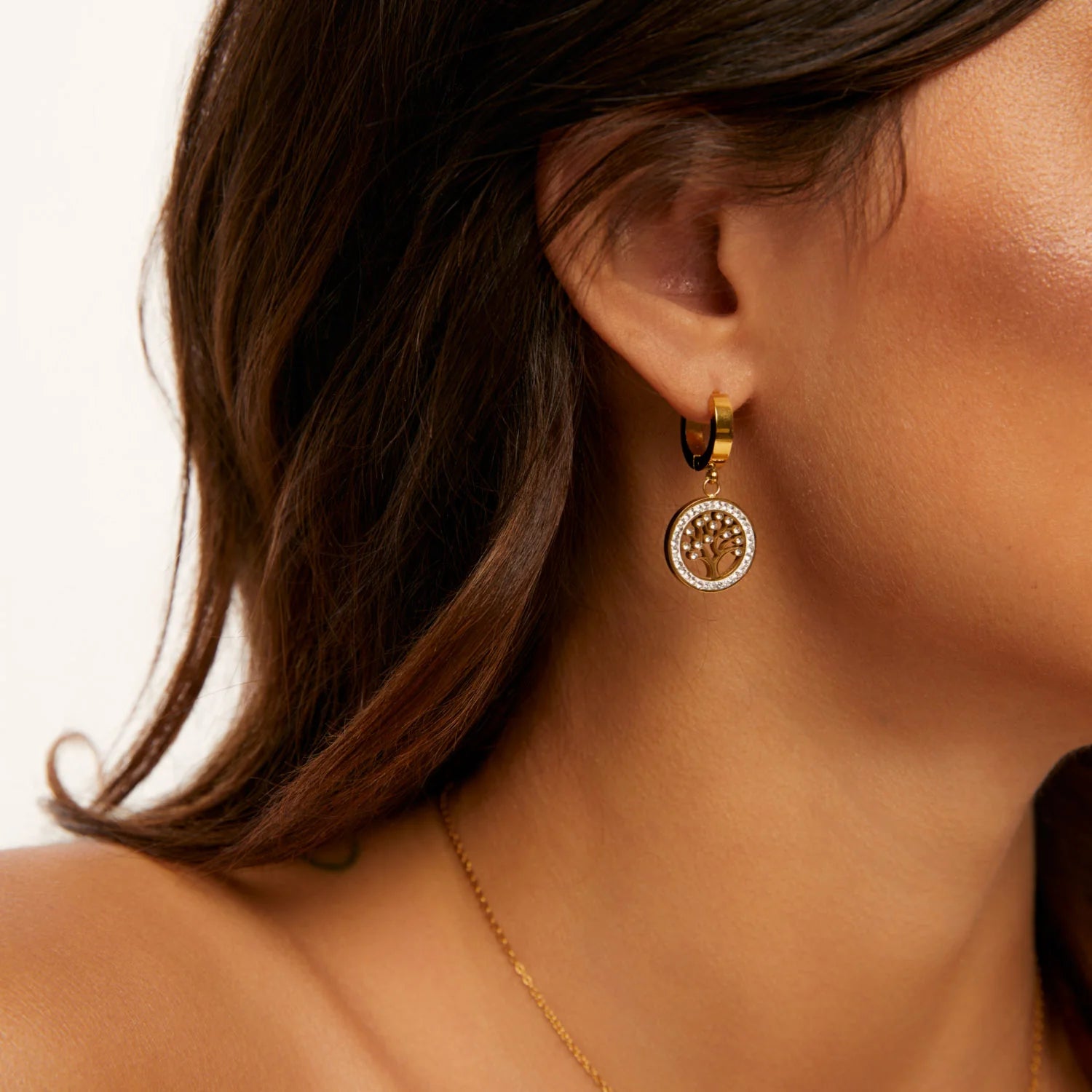 Aros dorados con argolla pequeña y dije redondo de Árbol de la Vida calado, rodeado de zirconias brillantes en baño de oro 18K de ZAYA 