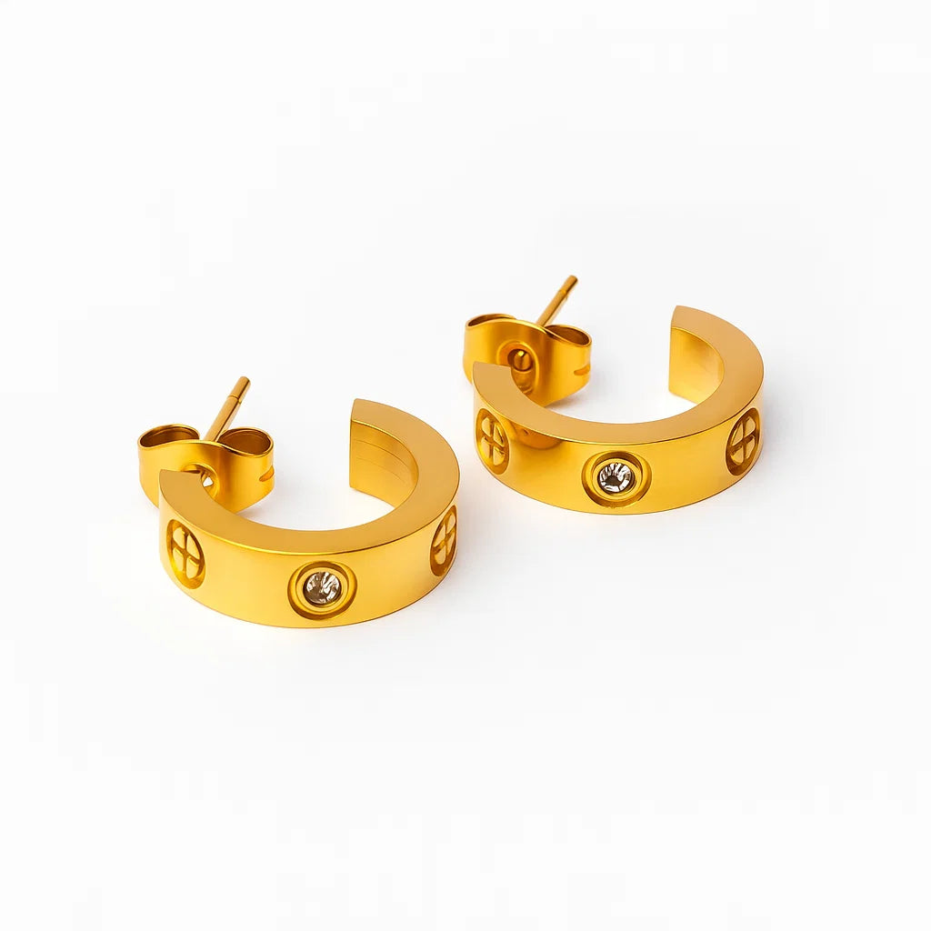Par de aros argolla media luna dorados con zirconias y detalle tipo tornillo, baño de oro 18K sobre acero inoxidable 316L.