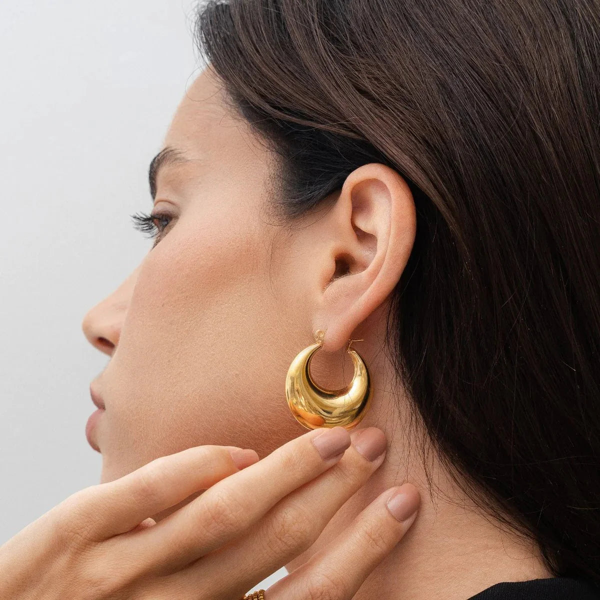 Aros dorados voluminosos estilo media luna, acabado liso y brillante, baño de oro 18K en acero inoxidable 316L.