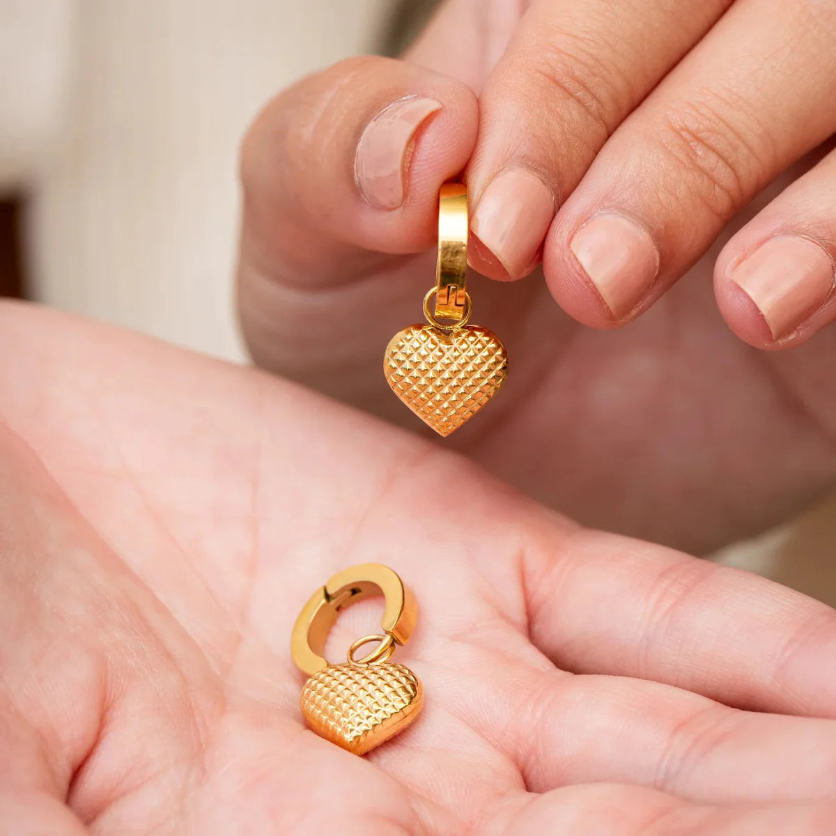 Aros ZAYA huggie con dije de corazón texturizado, baño de oro 18K; a prueba de agua, no se oscurecen, hipoalergénicos y con garantía de por vida.