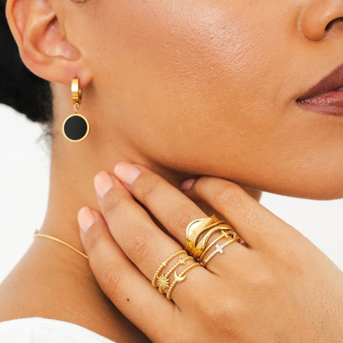 Aros huggie dorados con dije redondo negro estilo ónix, baño de oro 18K en acero inoxidable 316L.