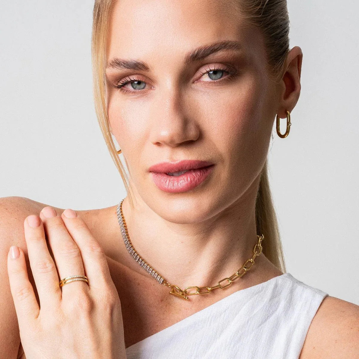 Aros ovalados dorados con pequeña circonia al frente, baño de oro 18K en acero inoxidable 316L.