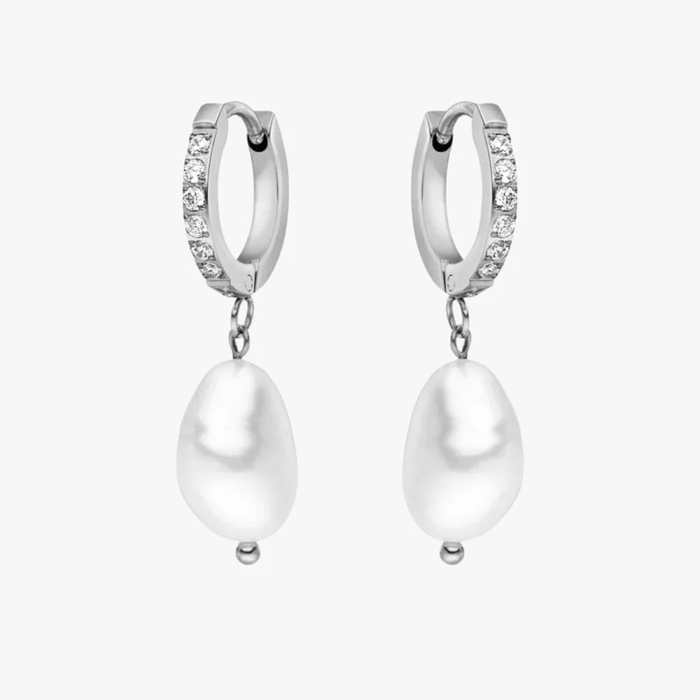 Aros de argolla con pequeñas zirconias en la parte frontal y perla de río blanca colgante en cada aro, en baño de oro 18K de ZAYA sobre fondo blanco