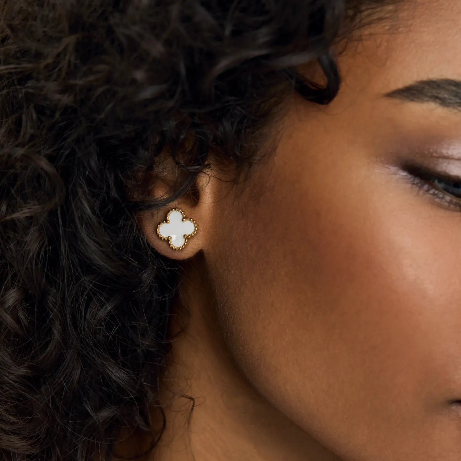 Aros ZAYA tipo stud con trébol blanco esmaltado y borde texturizado, baño de oro 18K; hipoalergénicos, a prueba de agua y con garantía de por vida.