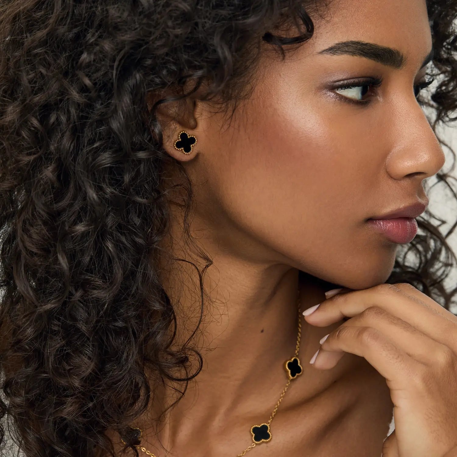 Aros ZAYA tipo stud con trébol negro esmaltado y borde texturizado, baño de oro 18K; hipoalergénicos, a prueba de agua y con garantía de por vida.