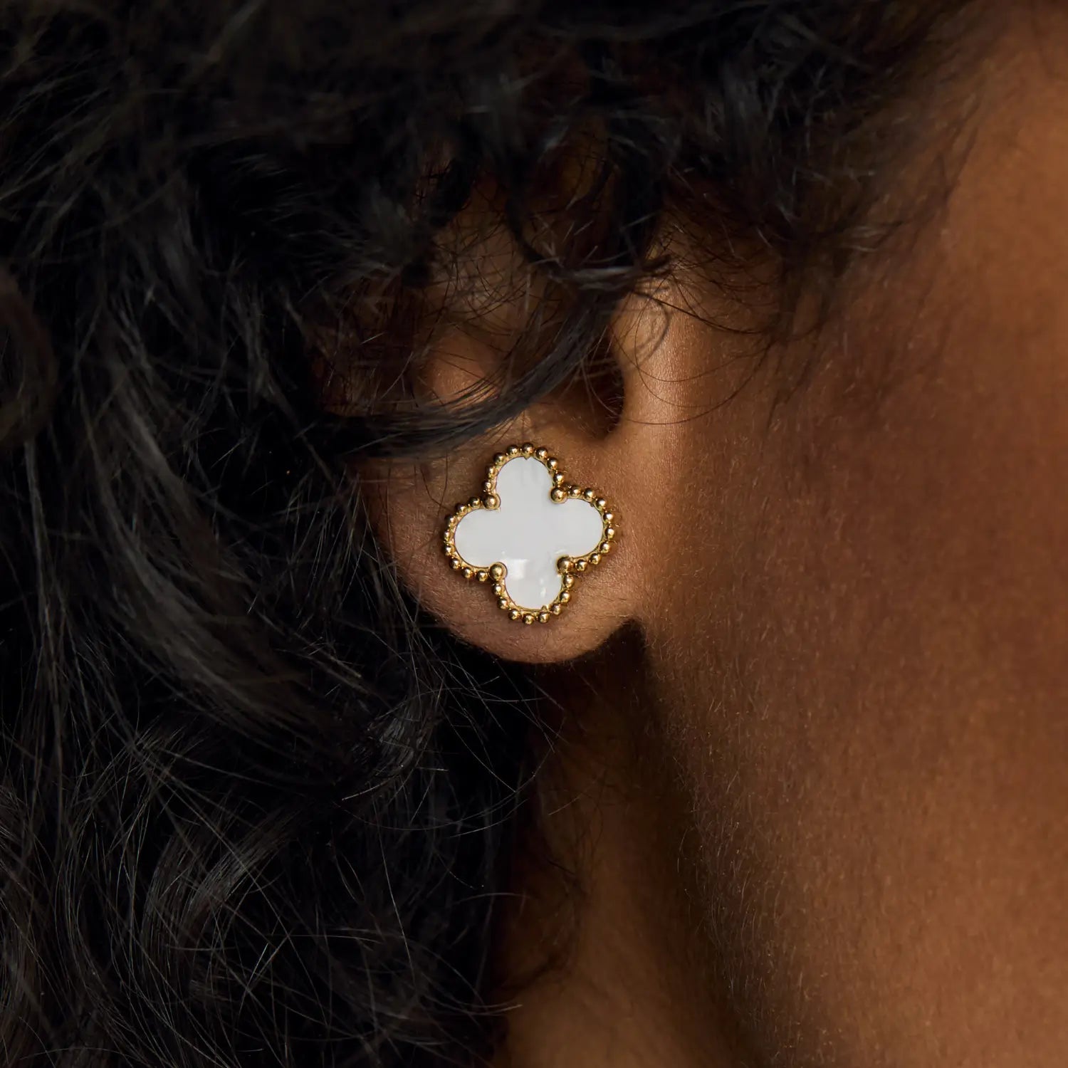 Aros ZAYA tipo stud con trébol blanco esmaltado y borde texturizado, baño de oro 18K; hipoalergénicos, a prueba de agua y con garantía de por vida.