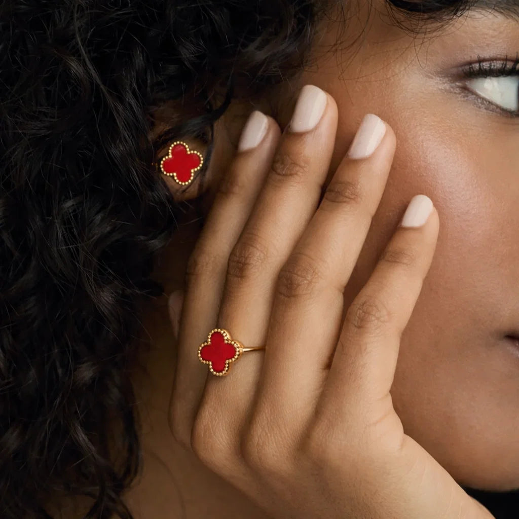 Aros ZAYA tipo stud con trébol rojo esmaltado y borde texturizado; acero inoxidable, baño de oro 18K; hipoalergénicos, a prueba de agua y con garantía de por vida.