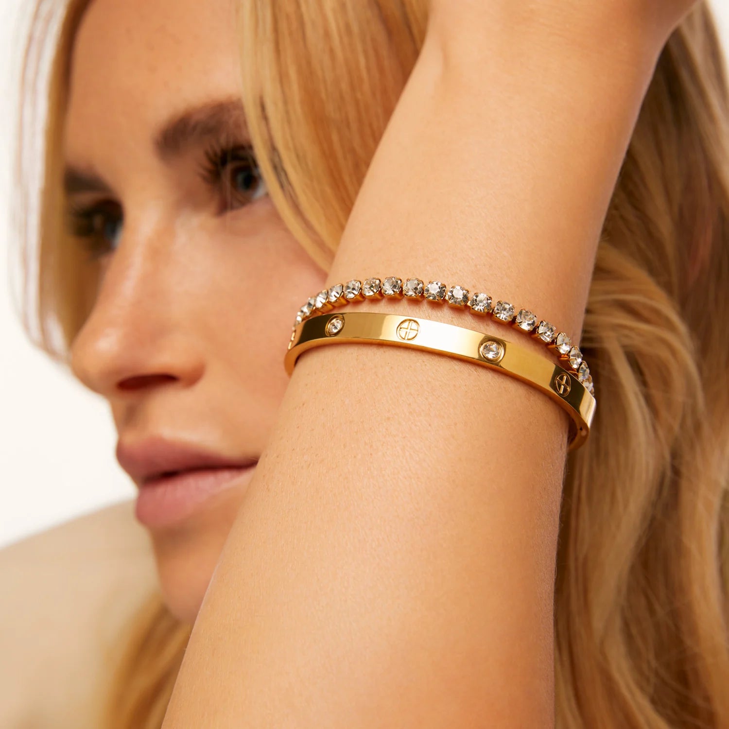 Brazalete rígido con detalles tipo tornillo y zirconias incrustadas. Baño de oro 18K; hipoalergénico, a prueba de agua y con garantía de por vida.