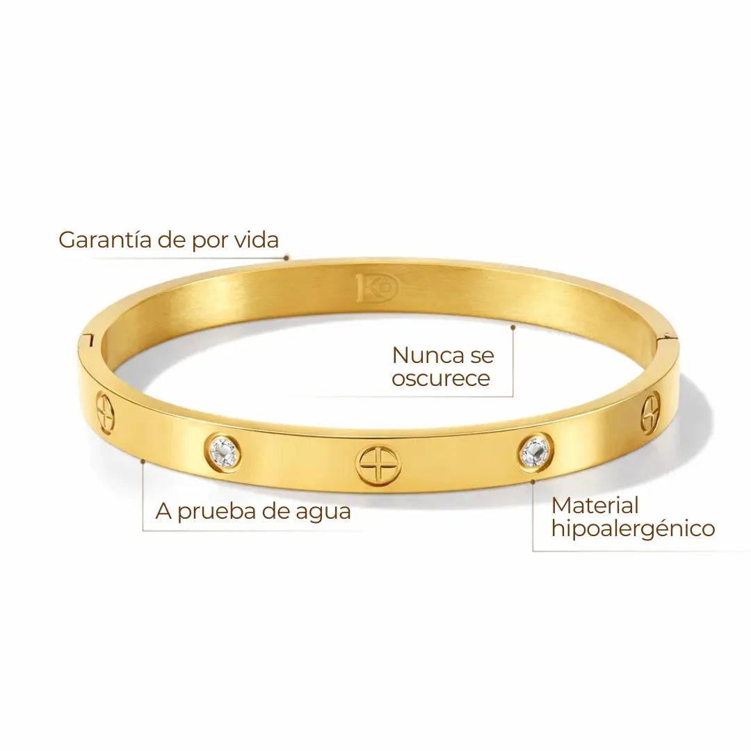 Brazalete rígido con detalles tipo tornillo y zirconias incrustadas. Baño de oro 18K; hipoalergénico, a prueba de agua y con garantía de por vida.