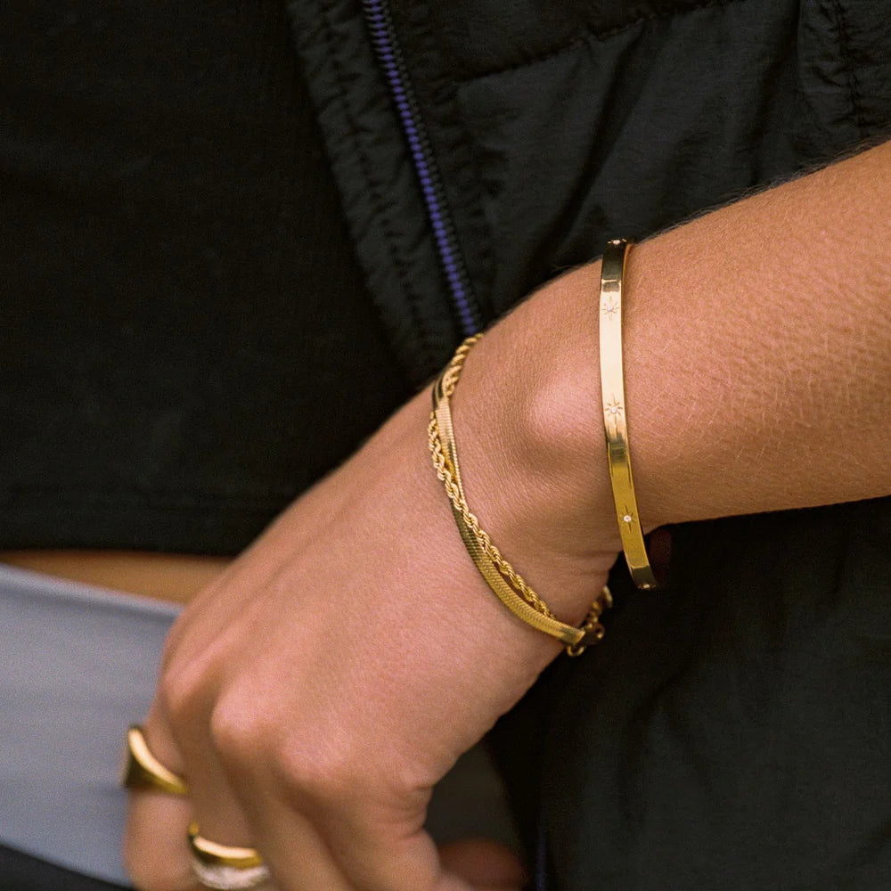 Brazalete Estelar ZAYA rígido con grabados de estrellas y circonias, baño de oro 18K; hipoalergénico, a prueba de agua y con garantía de por vida.