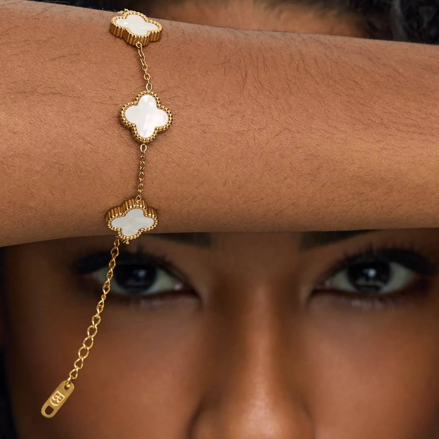 Pulsera ZAYA con tréboles blancos esmaltados y borde texturizado, baño de oro 18K; hipoalergénica, a prueba de agua y con garantía de por vida.